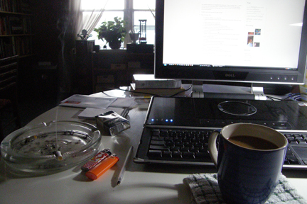 My Desk piles, cigs, and artificial light