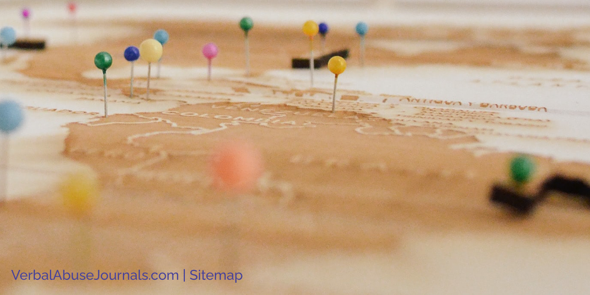 Map pins in a map lying horizontally on the floor. Words say Verbalabusejournals.com, Sitemap