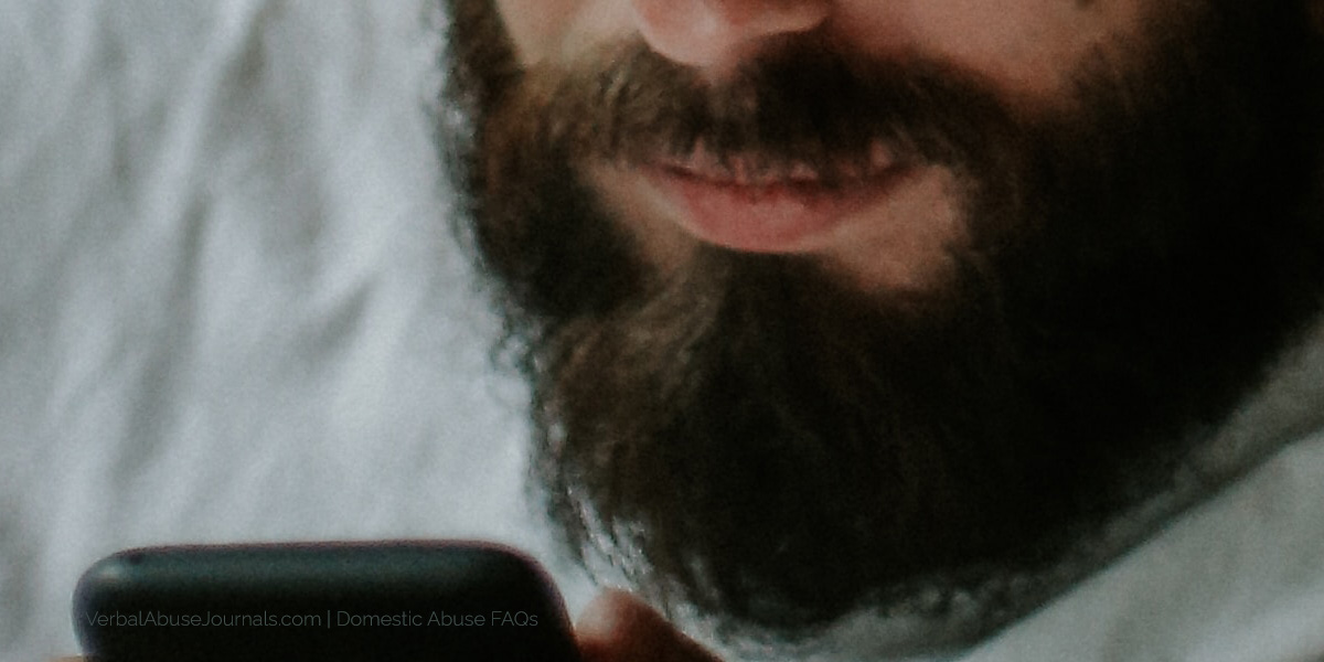 A man with a beard on a cell phone, featured image for domestic abuse faqs pate