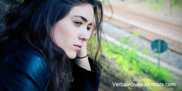 woman looking out a window thoughtfully as she needs to set some boundaries to protect her from abuse