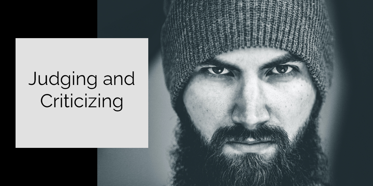 man with a beard wearing a beanie, looking at you as if you did something wrong. Judging and criticizing you constantly.